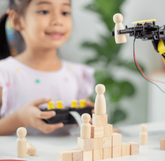 A young girl joyfully explores a robot STEM toy, enhancing her creativity and engineering skills.