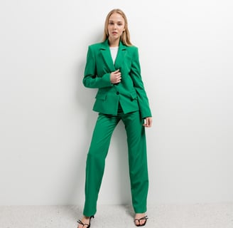 a woman in a green suit and heels