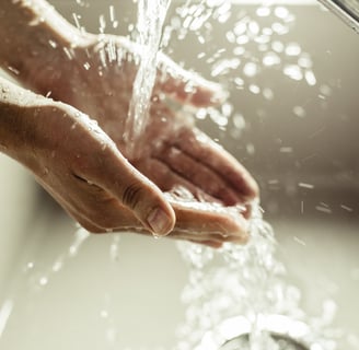 a person's hands are shown with water flowing from the water
