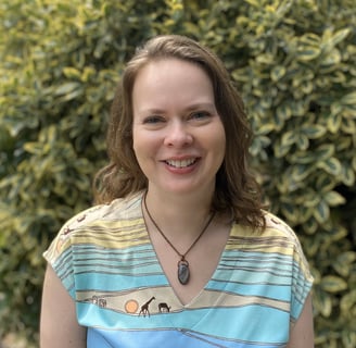 Woman smiling and standing in front of garden