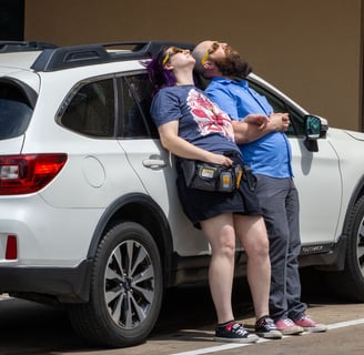 A couple lays against the side of their car to watch the progression of the solar eclipse together. Photo by Taylor Pleasant