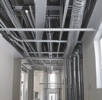 Multiple air conditioning units are mounted on the exterior of a tall building's facade. The structure features numerous small rectangular windows, many of which are open. Vertical red lines divide the facade, creating a repetitive pattern. The overall look is industrial and urban.