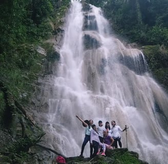 a group of people standing around a waterfall