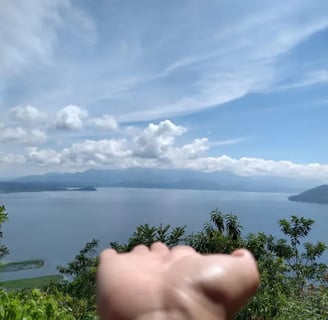 a person holding their hand up to the camera lago de yojoa hijasdelamontanahn