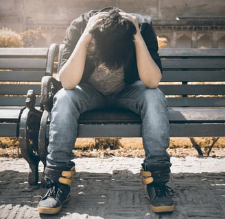 a person sitting on a bench with a backpack