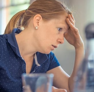 a woman sitting at a table with a laptop computer