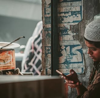 a young boy is looking at his cell phone