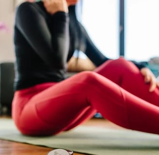 a woman sitting on a yoga mat with a cell phone