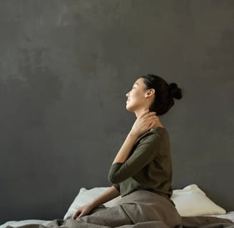 a woman sitting on a bed with a blanket on it