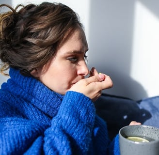 a woman in a blue sweater is holding a cup of coffee