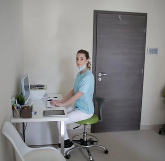 a woman sitting at a desk with a laptop computer