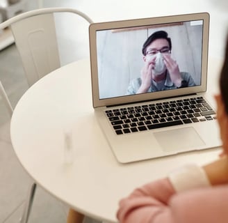 a woman sitting at a table with a laptop computer