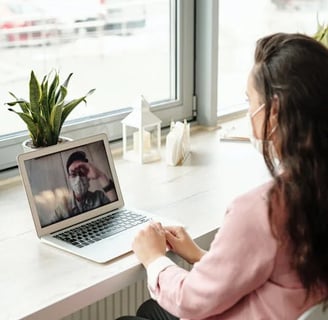 a woman sitting at a desk with a laptop computer