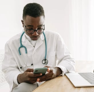 a male doctor in a white coat and a laptop