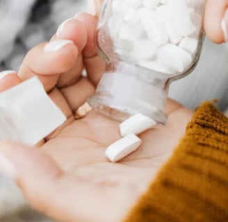 a person holding a jar of pills and pills