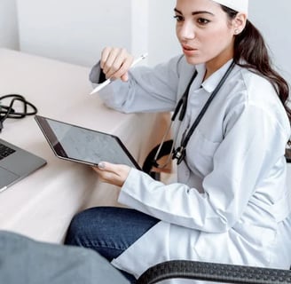 a woman doctor in a white coat and a laptop