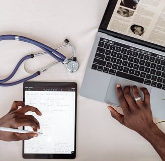 a man is sitting at a desk with a laptop and a stethoscope