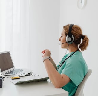 a woman in a green shirt and headphones is sitting at a desk