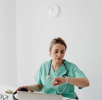 a nurse in scrubs and a stethoscope on a laptop