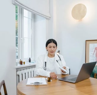 a woman in a white lab coat is sitting at a table