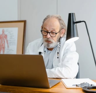 a man in a lab coat and glasses is sitting at a desk