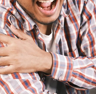 a man with a beard and a beard, smiling and holding his hands up to