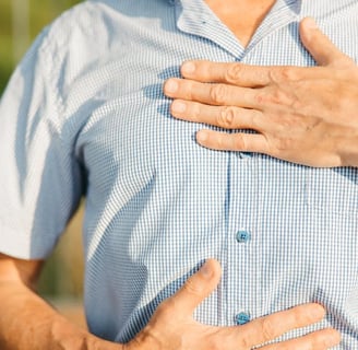 a man with a chest pain holding his chest