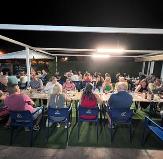 a group of people sitting at a table with food