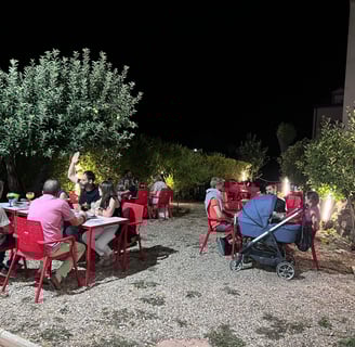 a group of people sitting at tables outside