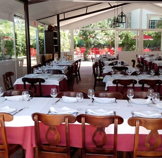 a restaurant with tables and chairs and a table with plates and glasses