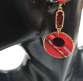 a woman's earring with a red and black earrings