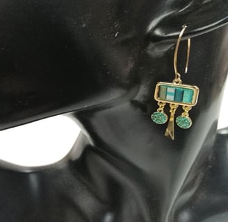 a pair of earrings with turquoise and gold earrings