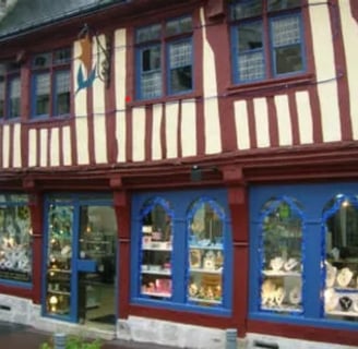 a store front of a building with a clock on the outside