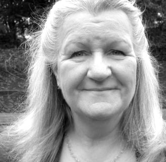 A black and white headshot of a woman in her 60s.