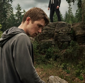a man in a suit and tie standing on a rock