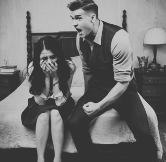 a man and woman sitting on a bed