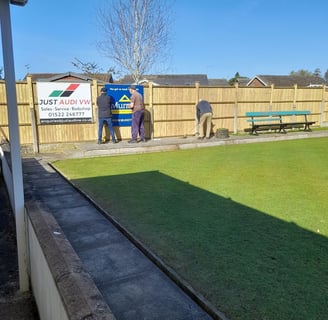 Members replace the sponsors signs on our new fence
