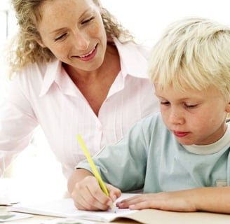 Graphothérapeute professionnelle accompagnant un jeune élève à perfectionner sa technique d'écriture à Conflans-Sainte-Honori