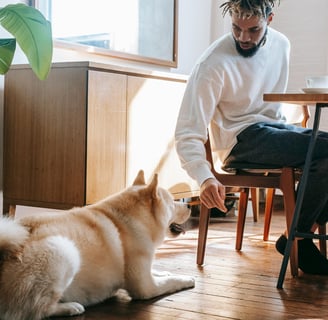 a man sitting at a table with a dog