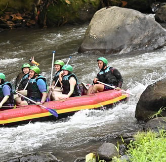 Tourists enjoying thrilling white water rafting adventure in Ubud Bali jungle river