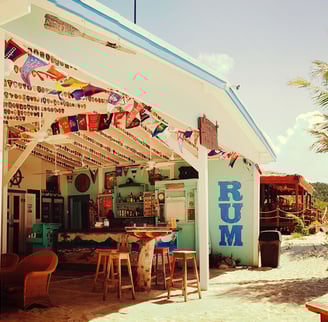 The open patio at Soggy Dollar, with tables and umbrellas