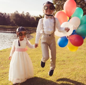 a man and a little girl are holding balloons