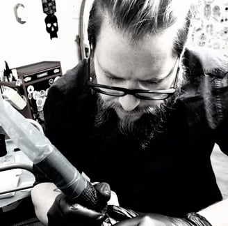 Le tatoueur Vehemdeh en train de tatouer