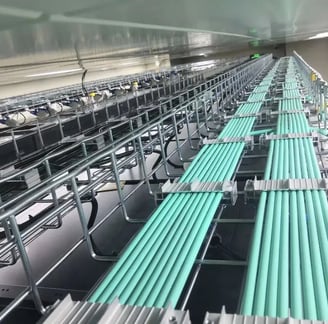 una bandeja de cables de malla de alambre con cables verdes y fijador de cables