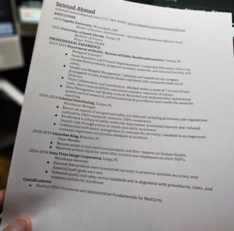 a person holding a paper with Sennad Ahmad's  resume