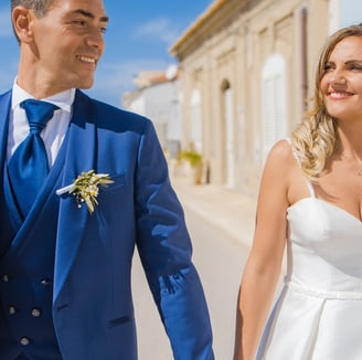 sposo e sposa che passeggiano al mare