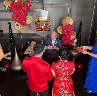 A family celebrating with each other with the Chinese tea ceremony backdrop