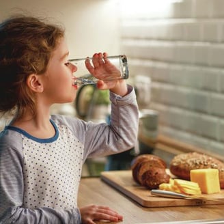 Woman enjoying clean filtered water from Premier Water system