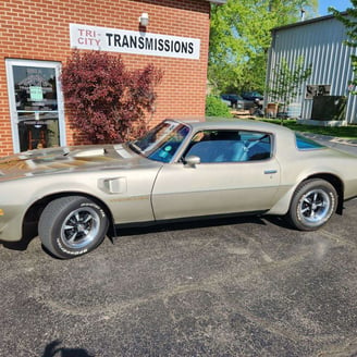 a tan tan car parked in front of a building