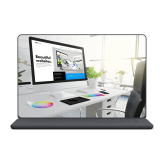 Modern workstation with iMac showing web design, colorful swatches, and plants in a bright office setting.